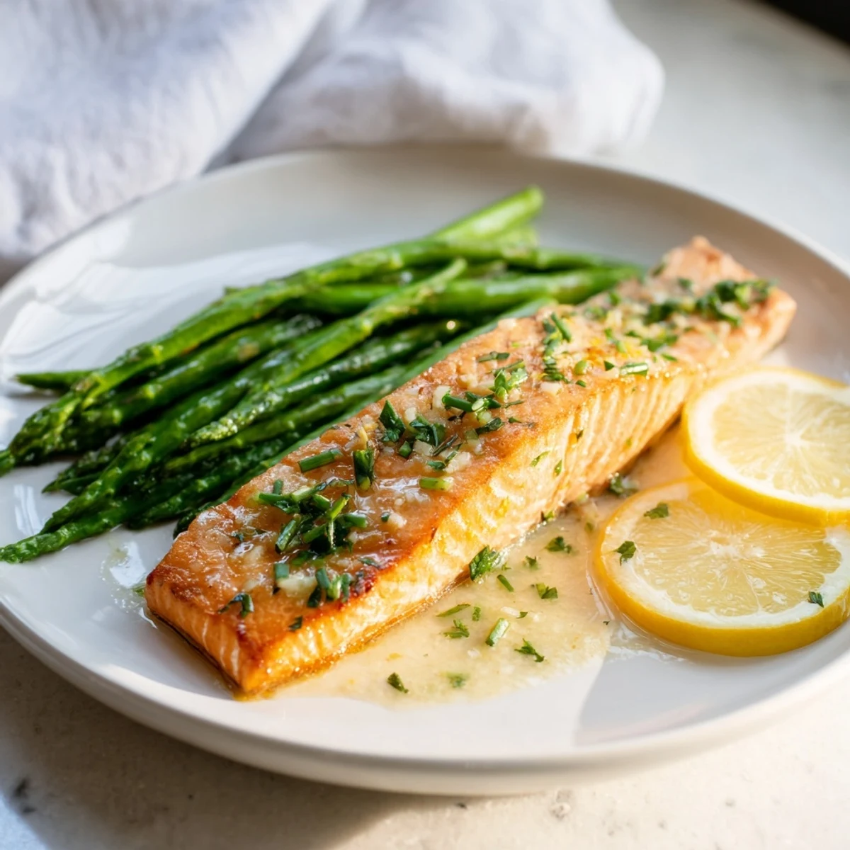 Juicy, flaky Skillet Lemon-Butter Salmon, cooked with asparagus in a luscious, garlic-infused lemon-butter sauce.