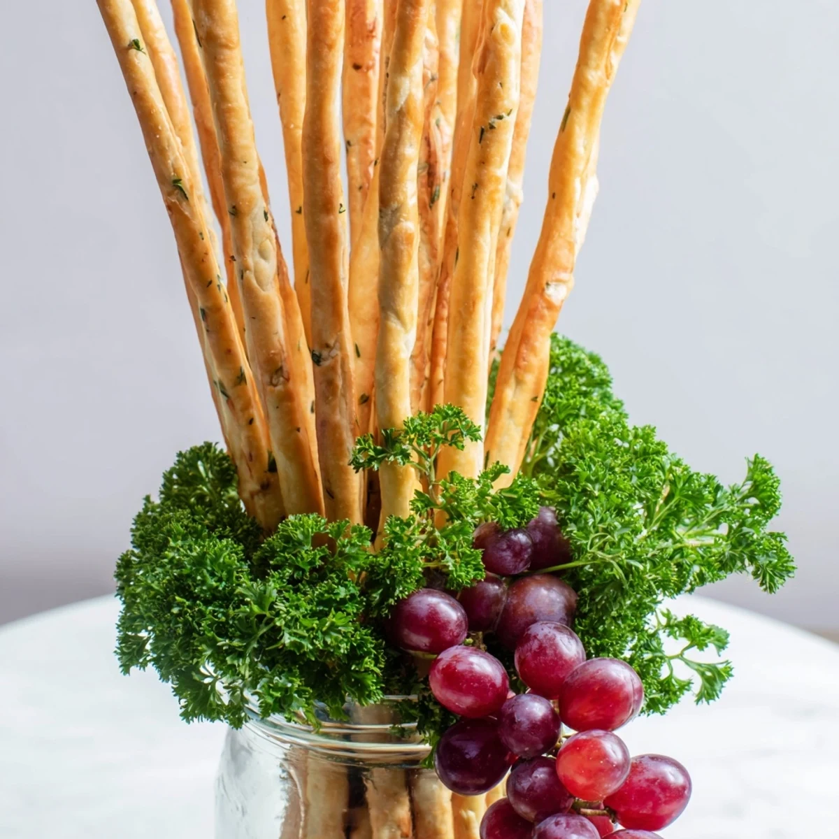 Appetizing The Vertical Forest: Tall breadsticks create a forest with grapes and parsley for a party snack.