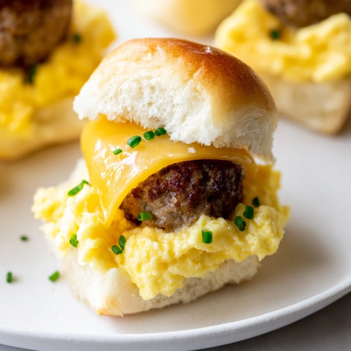 Golden toasted buns hold savory sausage patties and gooey cheese in these Mini Breakfast Sliders.