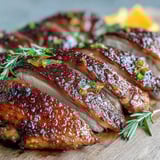Juicy Five-Spice Roast Ducks glistening with a honey glaze, surrounded by aromatic star anise and orange wedges.