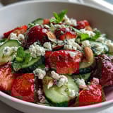 A vibrant spring salad with crisp cucumber, juicy strawberries, and fresh mint in a light lemon dressing.