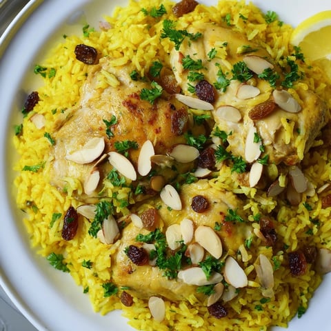 Golden saffron chicken and rice pilaf, a warm, inviting bowl ready to serve with lemon.