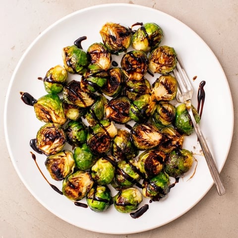 Caramelized roasted Brussels sprouts on a platter with glistening balsamic glaze, ready to serve as a savory side.