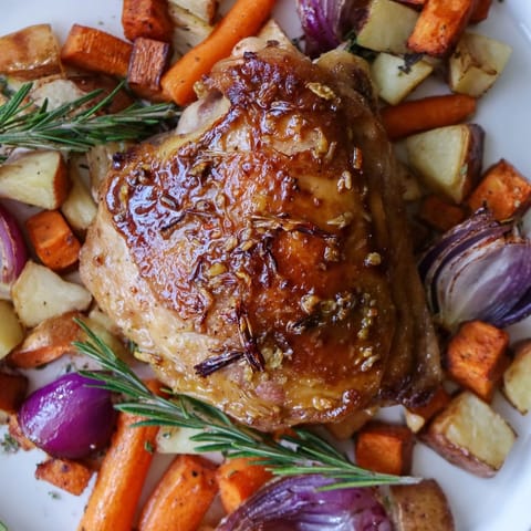 Comforting Honey-Glazed Chicken with Roasted Root Vegetables baking in the oven, aromatic with thyme and rosemary.