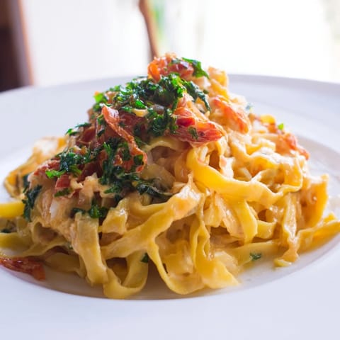 Golden, steaming One-Pot Creamy Tuscan Garlic Herb Pasta, ready to savor with fresh basil, for four.