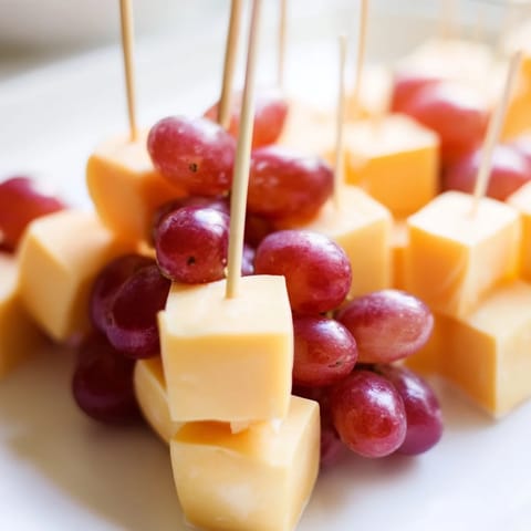 Skewered cheese and juicy red grapes, a visually appealing snack ideal for gatherings.