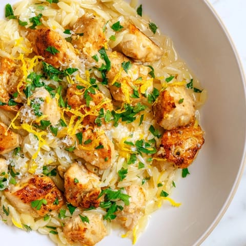 A close-up view of the Creamy Lemon Chicken Orzo, garnished with fresh parsley and lemon slices.