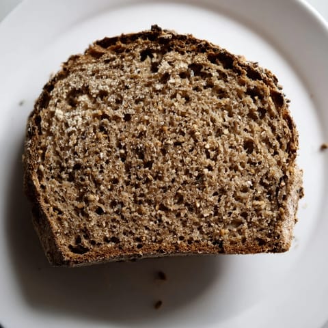 Dense, aromatic Latvian Rupjmaize bread, freshly baked with a wonderfully chewy interior, perfect for serving.