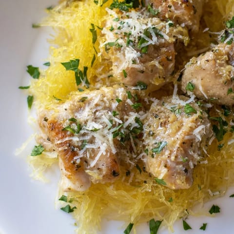 Freshly cooked Lemon Garlic Chicken Spaghetti Squash plated with juicy chicken, roasted squash strands, and melted Parmesan cheese.