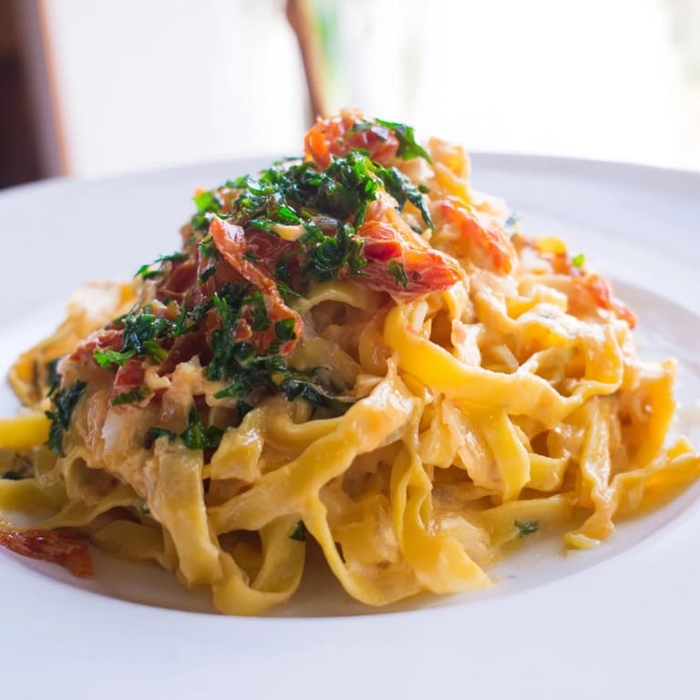 Golden, steaming One-Pot Creamy Tuscan Garlic Herb Pasta, ready to savor with fresh basil, for four.