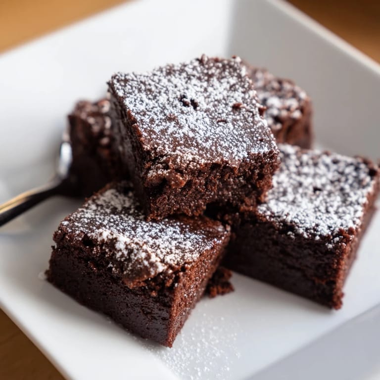 Warm, rich brownie squares, beautifully dusted with powdered sugar, perfect treat for dessert lovers.