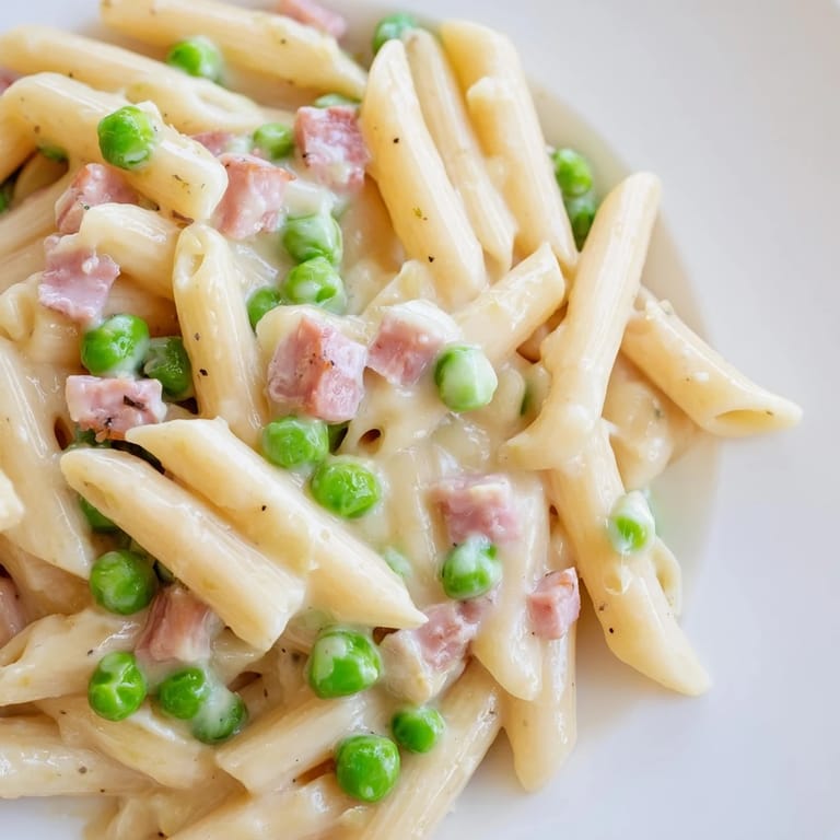 Spring Pea & Ham Pasta served in a white bowl, highlighting the creamy Parmesan sauce and fresh herbs.